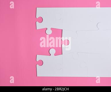white large blank puzzles on a pink background, top view, copy space Stock Photo