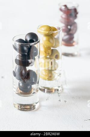 Assortment of three species of olives in glasses on the white background Stock Photo