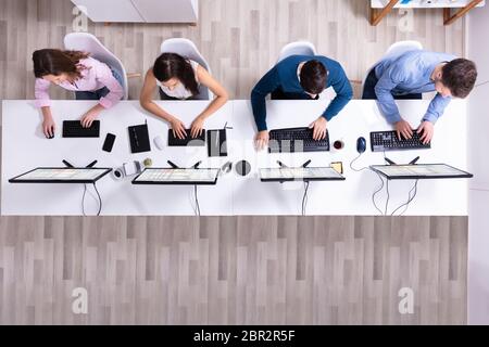Young Businesspeople Analyzing Gantt Chart On Computer At Workplace Stock Photo