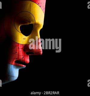 Side view of a scary halloween face mask with a used archery target as skin. Concept of target skin conditions. Black copy space. Stock Photo