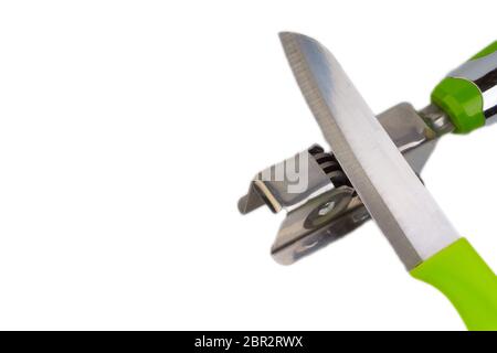 Knife, kitchen tools and knife sharpener isolated on white background. Selective focus and crop fragment Stock Photo