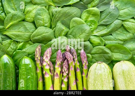 Green vegetables background. Flat lay of asparagus, spinach, cucumber and zucchini. Healthy food and dietary concept. Copy space for text Stock Photo