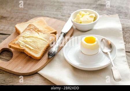 Boiled egg with crispy toasts on the wooden table Stock Photo