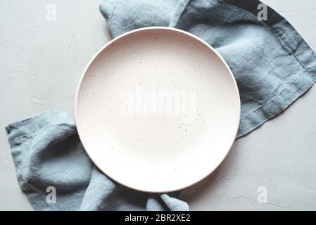 An empty plate and napkin on the gray background. Stock Photo