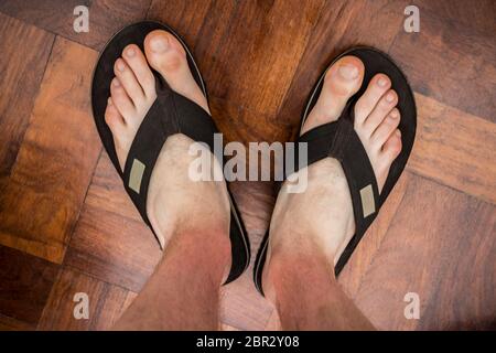 Brown flip flops on brown floor texture background. Vacation clothes. Stock Photo