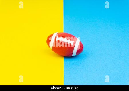 Rugby ball on blue and yellow background. Selective focus Stock Photo