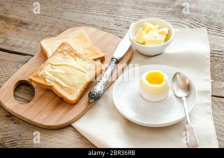 Boiled egg with crispy toasts on the wooden table Stock Photo