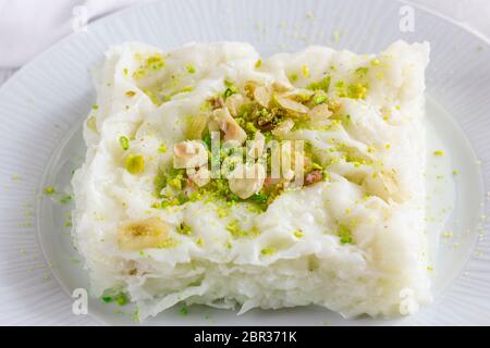 Traditional turkish meal - Gullac. Milk dessert sprinkled with ground nuts and pistachios. Ramadan dish Stock Photo