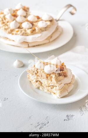 Pavlova cake with caramel and almonds on the wooden background Stock Photo