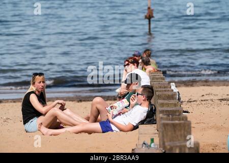 Portobello, Scotland, UK. 20 May 2020. Hot sunny weather brought out large crowds to Portobello beach today. Lockdown discipline seems to be a thing of the past with families and friends hitting the sand. A heavier than normal police presence had little visible effect since the public returned to the sand after the police walked away.  Iain Masterton/Alamy Live News Stock Photo