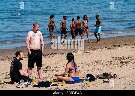 Portobello, Scotland, UK. 20 May 2020. Hot sunny weather brought out large crowds to Portobello beach today. Lockdown discipline seems to be a thing of the past with families and friends hitting the sand. A heavier than normal police presence had little visible effect since the public returned to the sand after the police walked away.  Iain Masterton/Alamy Live News Stock Photo