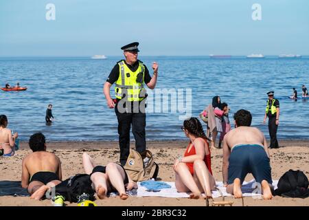 Portobello, Scotland, UK. 20 May 2020. Hot sunny weather brought out large crowds to Portobello beach today. Lockdown discipline seems to be a thing of the past with families and friends hitting the sand. A heavier than normal police presence had little visible effect since the public returned to the sand after the police walked away.  Iain Masterton/Alamy Live News Stock Photo