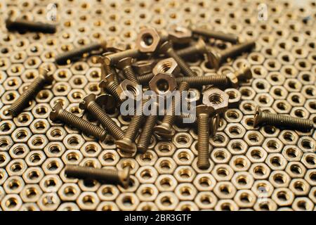 Close-up, macro. Old Soviet brass countersunk head screws with a flat head screwdriver. Texture, background of brass nuts laid out in the form of hone Stock Photo