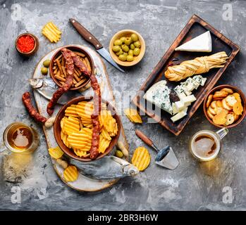 Large selection of snacks for beer. Set of cheeses, fish, chips and snacks Stock Photo