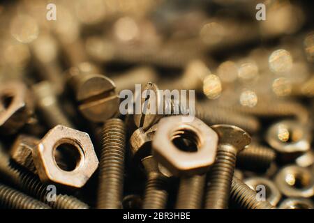 Close-up, macro. Old Soviet brass countersunk head screws with a flat head screwdriver. Texture, background of brass nuts laid out in the form of hone Stock Photo