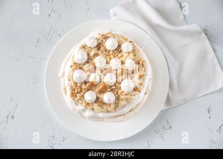 Pavlova cake with caramel and almonds on the wooden background Stock Photo