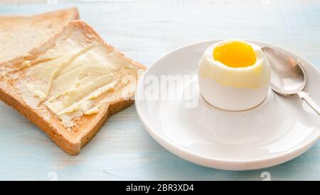 Boiled egg with crispy toasts on the wooden table Stock Photo