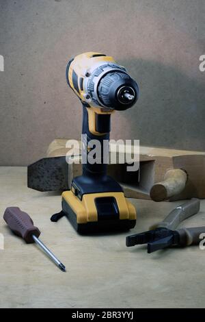 Tools for repair - drill, screwdriver, pliers and shirt on a light background. Stock Photo