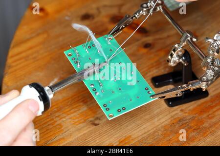 a worker is soldering some devices on workplace Stock Photo