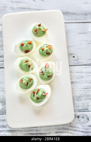 Spinach and bacon deviled eggs Stock Photo