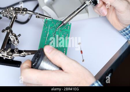 electric technician is soldering some digital devices Stock Photo
