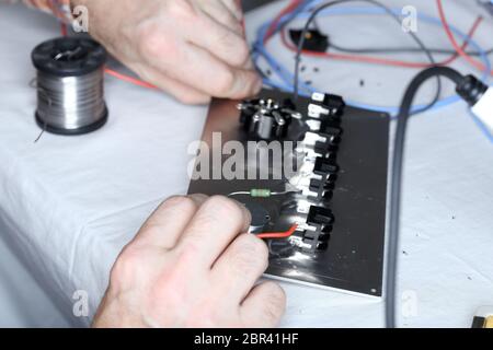 electric worker is mounting some devices on workplace Stock Photo