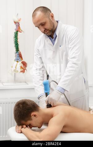 Extracorporeal Shockwave Therapy ESWT.Non-surgical treatment.Physical therapy for neck and back muscles,spine with shock waves.Pain relief Stock Photo