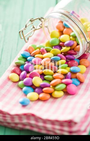 Colorful chocolate candy pills on checkered napkin. Stock Photo