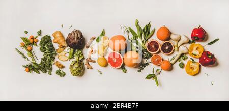 Variety of immunity boosting foods. Flat-lay of ginger, turmeric, kale, artichoke, citrus fruit, herbs, garlic, pepper over white background, top view Stock Photo