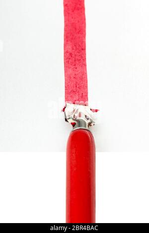 pov of red dip pen drawing a red line on sheet of paper by wide nib isolated on white background Stock Photo
