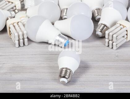 still life with white LED bulb lights and energy-saving lamps on gray wooden board Stock Photo