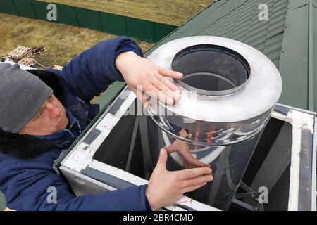 Aluminum ventilation chimneys, the master installs on the roof of the house. Smoke pipe for smoke from the kitchen.2020 Stock Photo