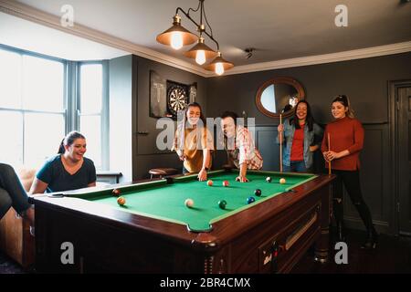 Billiards game. young friends playing pool together Stock Photo - Alamy