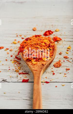 Spoonful of crushed red chili pepper over wooden background Stock Photo ...