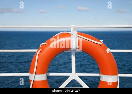 Lifebuoy and hand railing deck at cruise ship against seascape
