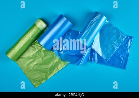 three rolled up rolls with plastic garbage bags on a blue background Stock Photo