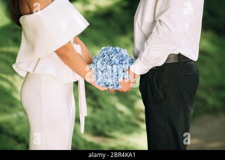 Bride And Groom Holding Hands Standing In Forest, Cropped Stock Photo