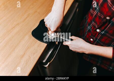 Barista presses ground coffee using tamper. Tool tamper. Coffee press is made of stainless steel Stock Photo