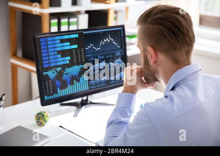Businessman Looking At Dashboard Analyzing KPI Graph On Computer Stock Photo
