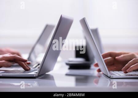 Close-up Of A Businessman Hands On Laptops Keypads On Desk In Office Stock Photo