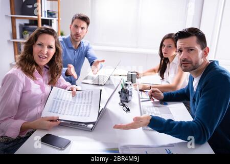 Group Of Business Executives Complaining Toward Camera In Office Stock Photo