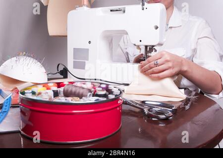 close up shot of a woman's hands, who is engaged in sewing in the home Stock Photo