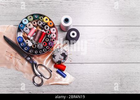 Tools for sewing. Sewing accessories on wooden background. Stock Photo