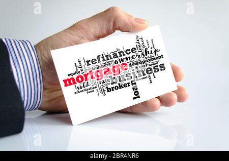 Mortgage word cloud collage over note in human hand Stock Photo