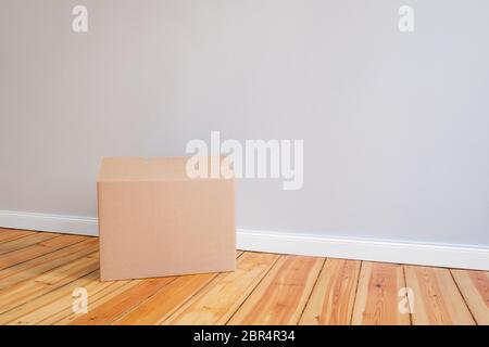 cardboard box on wooden floor in empty room,relocation concept Stock Photo