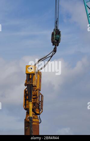 Close up of industrial crane lifting heavy machinery on the docks Stock Photo