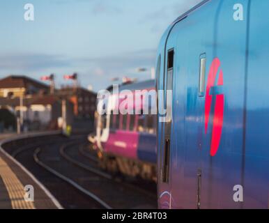 Northern rail class 158 train departing with a Firstgroup  logo on a Transpennine Express class 185 in the foreground at Blackpool North Stock Photo