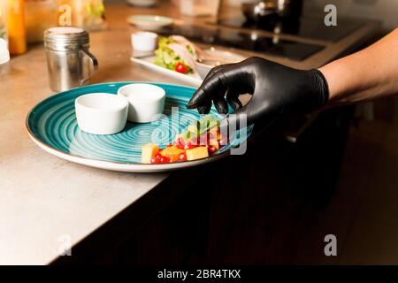 Chef preparing home made cottage cheese fried in a pan and served with sauces and fruit Stock Photo