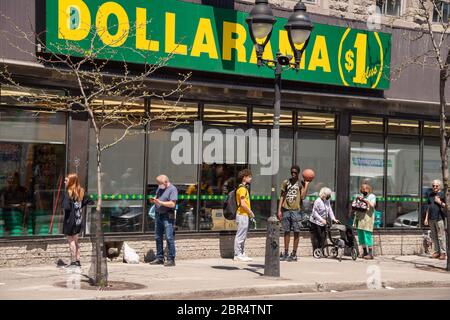 Montreal, CA - 20 May 2020: People in line at Dollarama store during Coronavirus pandemic on Mont-Royal Avenue. Stock Photo