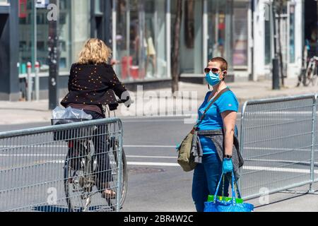 Montreal, CA - 20 May 2020: Woman with face mask for protection from COVID-19 waiting for the bus Stock Photo
